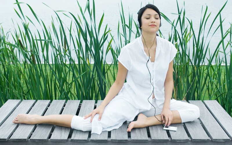 woman meditating by the water
