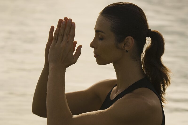 woman meditating by water