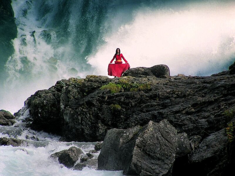 Woman meditating by waterfall