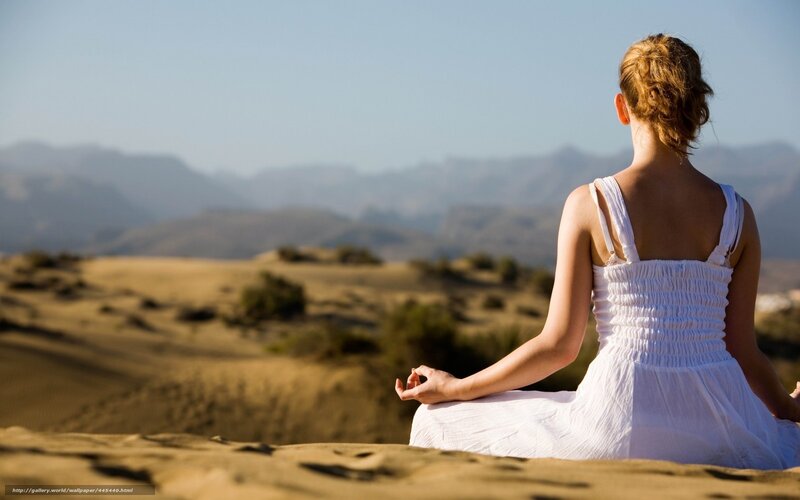 Woman meditating in desert
