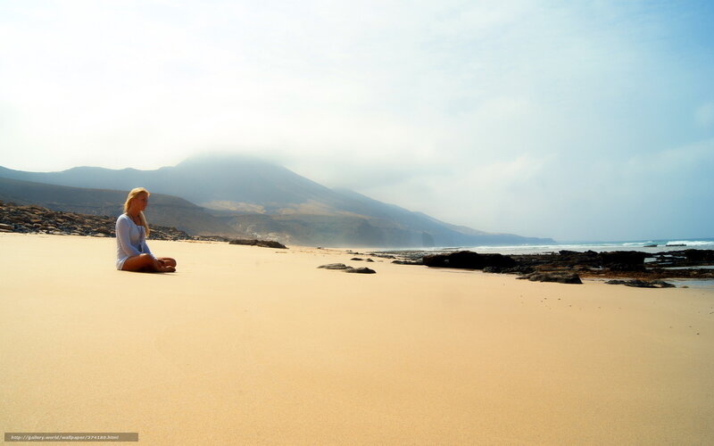 Woman meditating on a beach