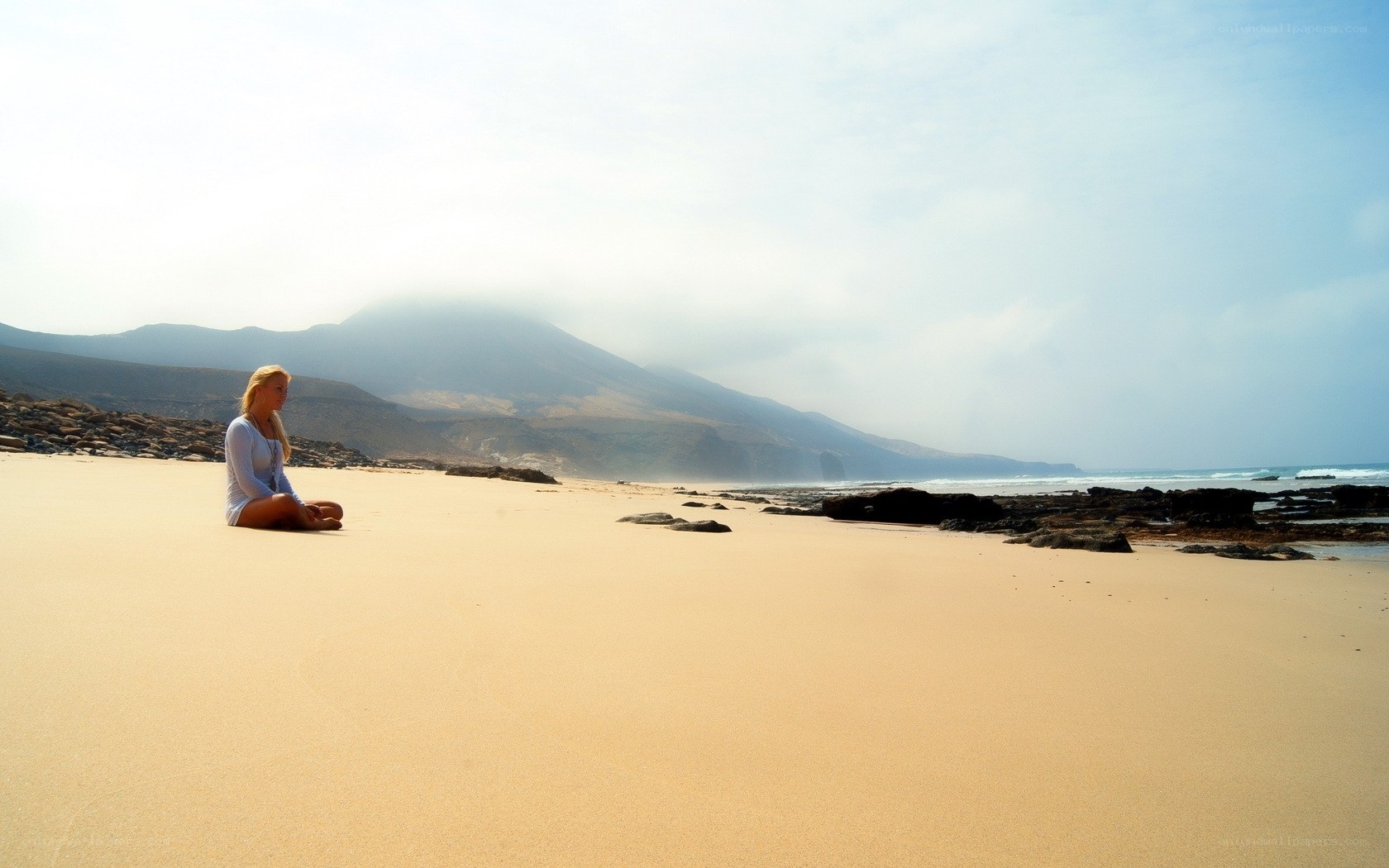 Woman meditating on a beach