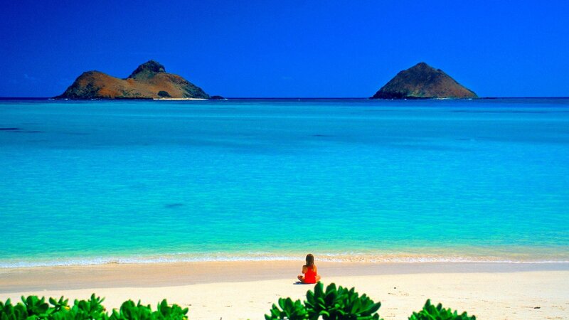 Woman meditating on a tropical beach