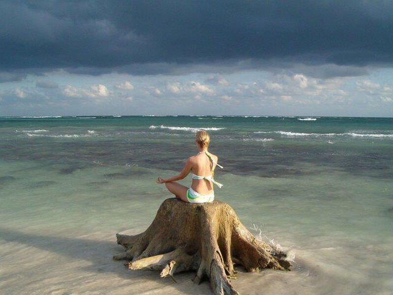 Woman Meditating on Driftwood