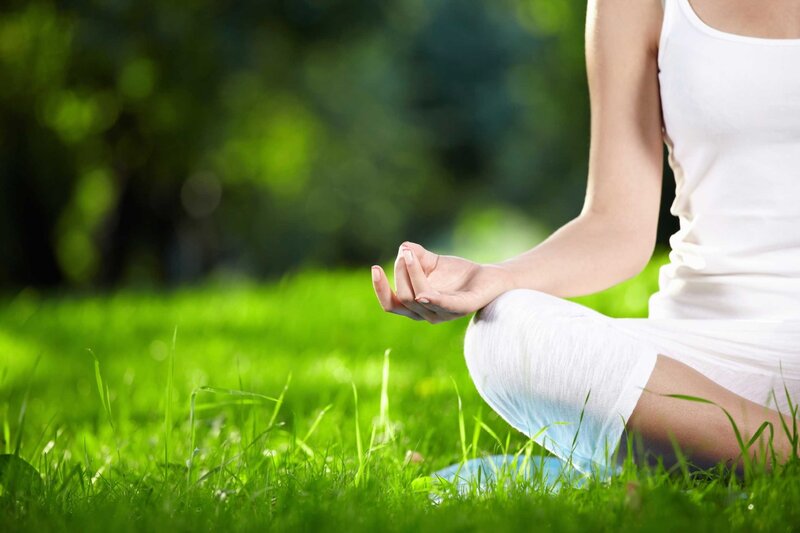 woman meditating on grass