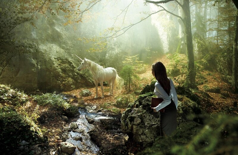 Woman meets unicorn in forest