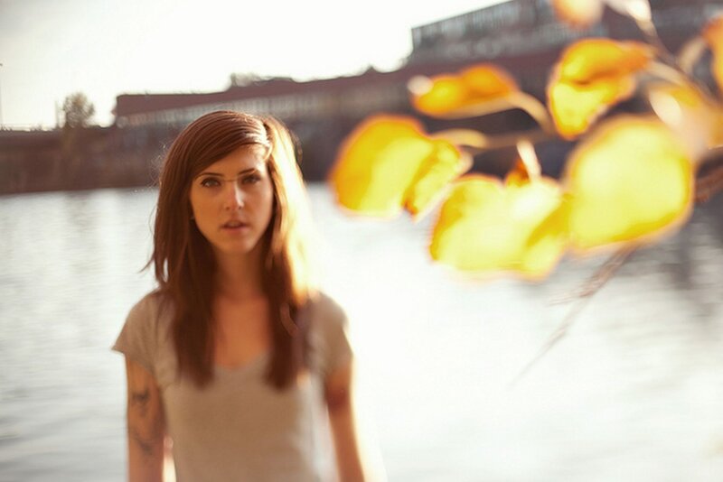 woman near water with autumn leaves