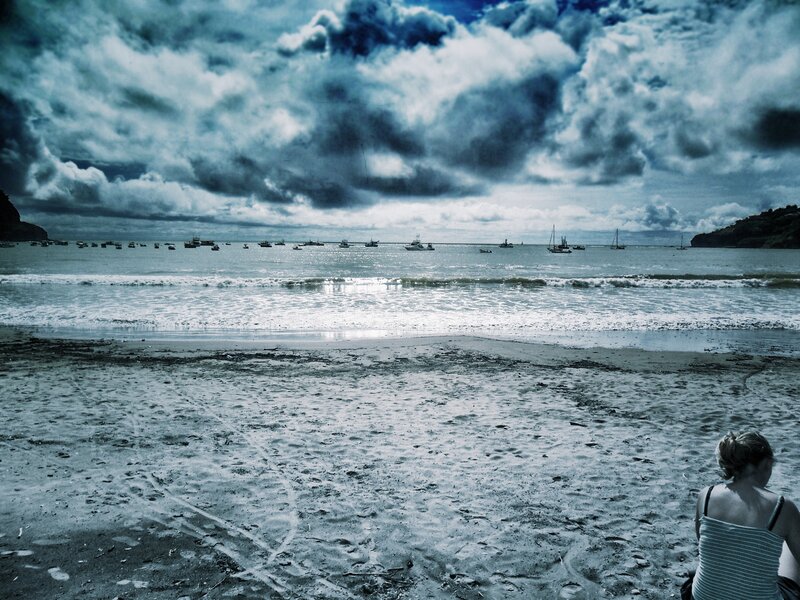 Woman on a beach under stormy sky