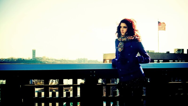 Woman on a bridge with flag