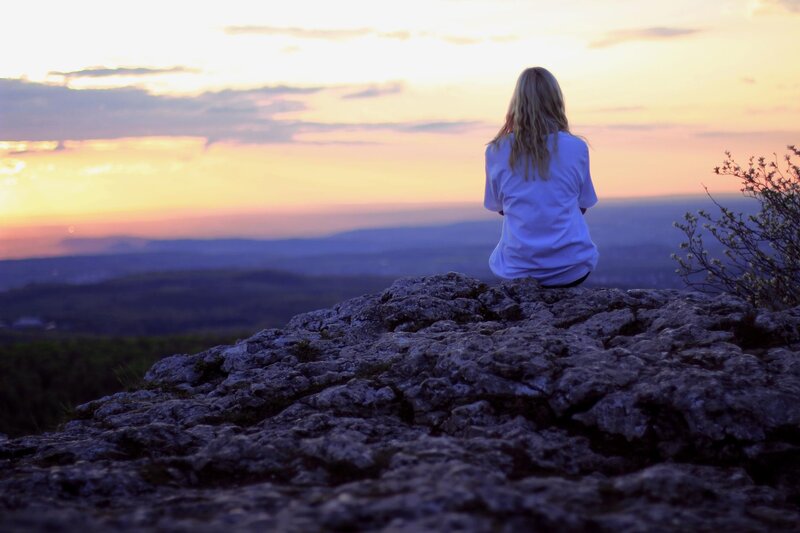Woman on a cliff at sunset