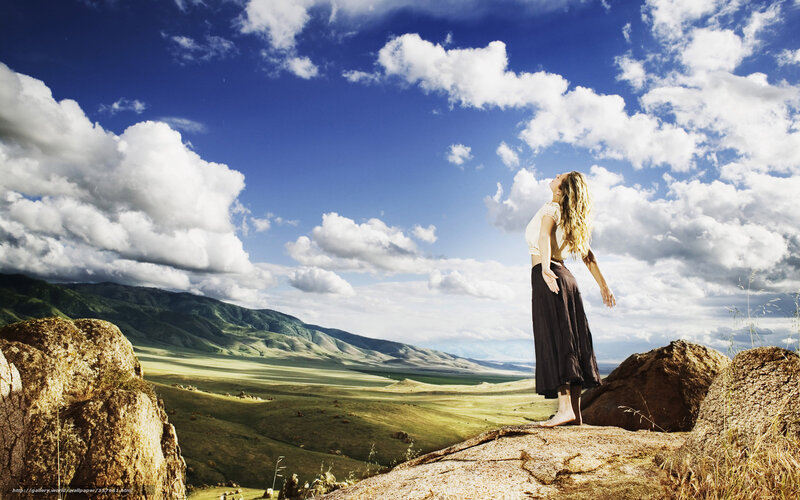 Woman on a cliff overlooking a valley