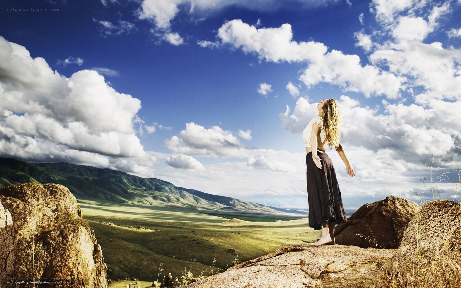 Woman on a cliff overlooking a valley
