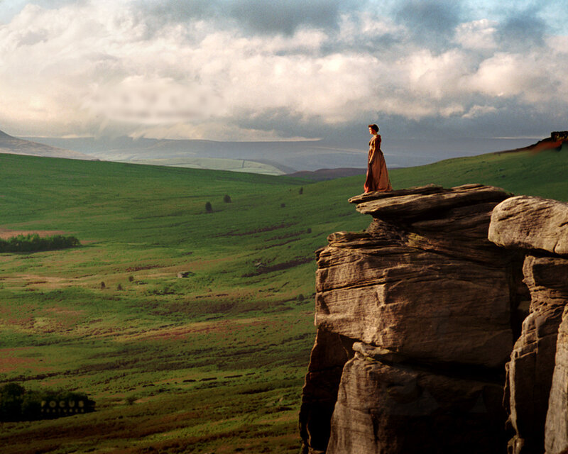 Woman on a cliff overlooking hills