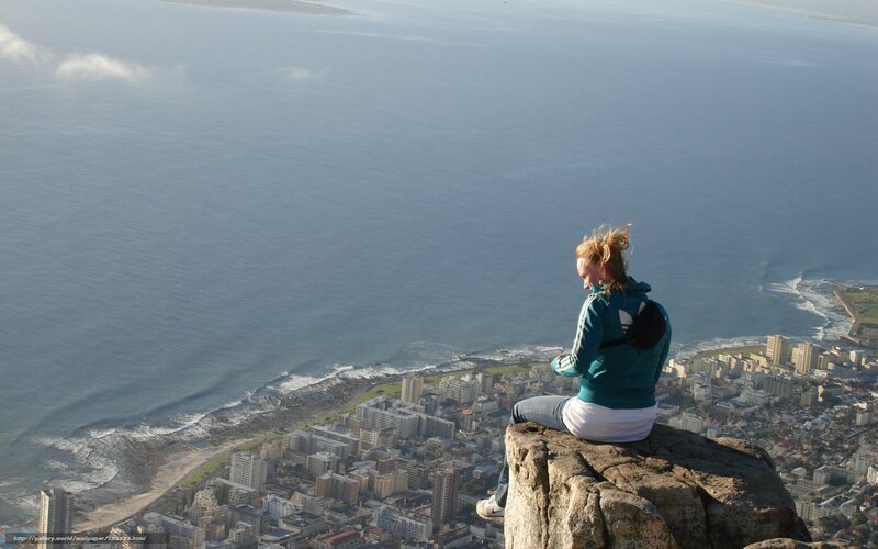 Woman on a cliff overlooking the city