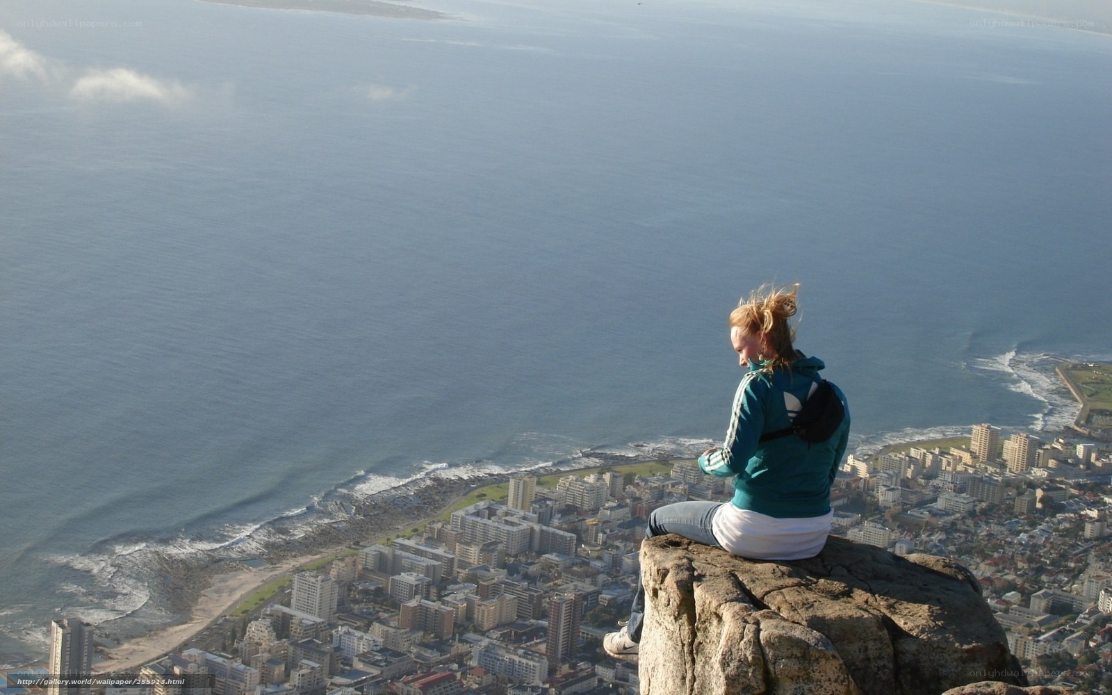 Woman on a cliff overlooking the city