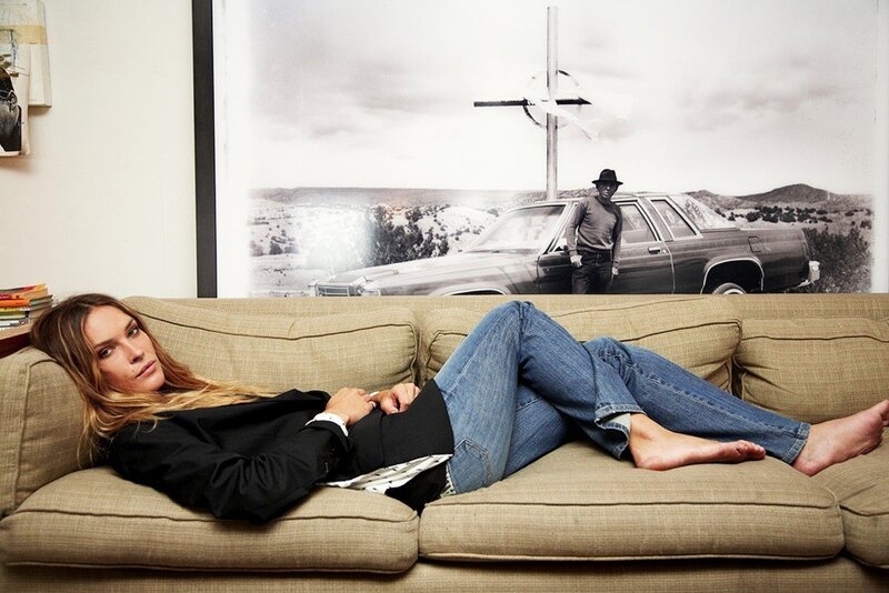 Woman on a couch with photo behind