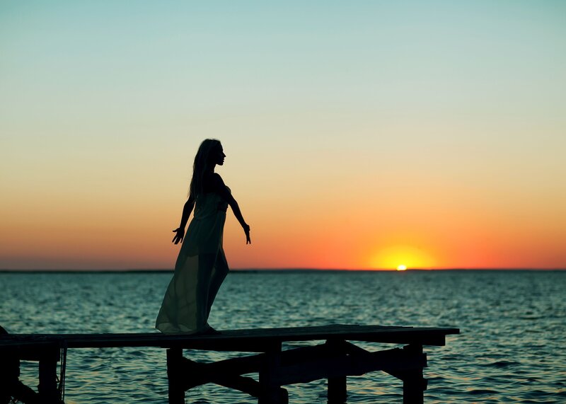 Woman on a Dock — Orange, Serene, Sunset