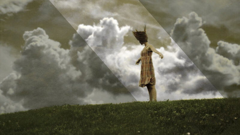 woman on a hill with stormy sky