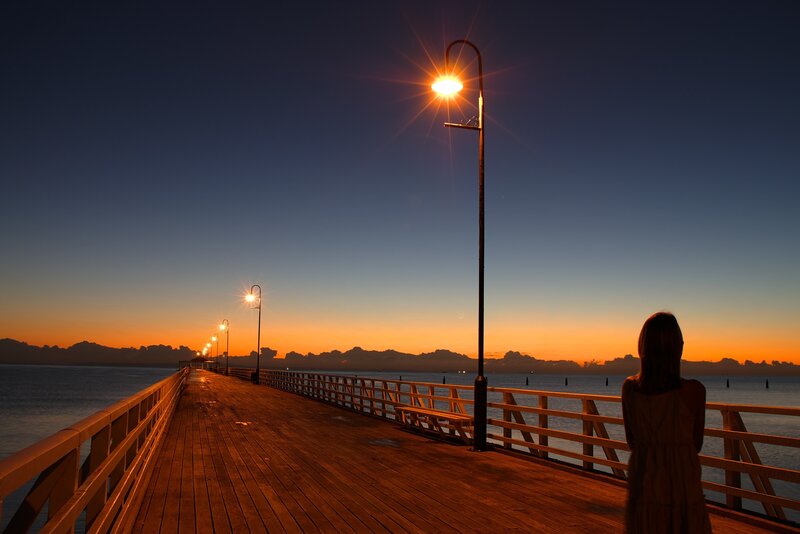 Woman on a Pier — Orange, Serene, Sunset