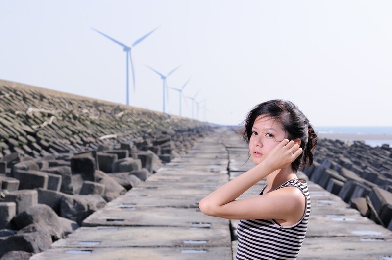 Woman on a pier with wind turbines