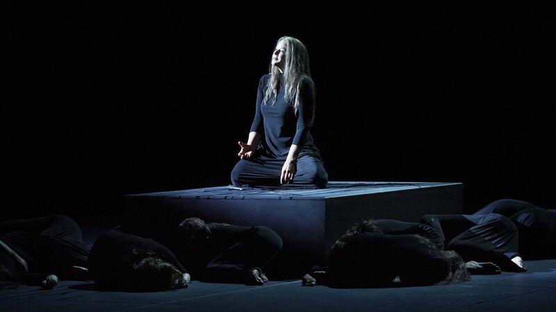 Woman on a platform surrounded by people