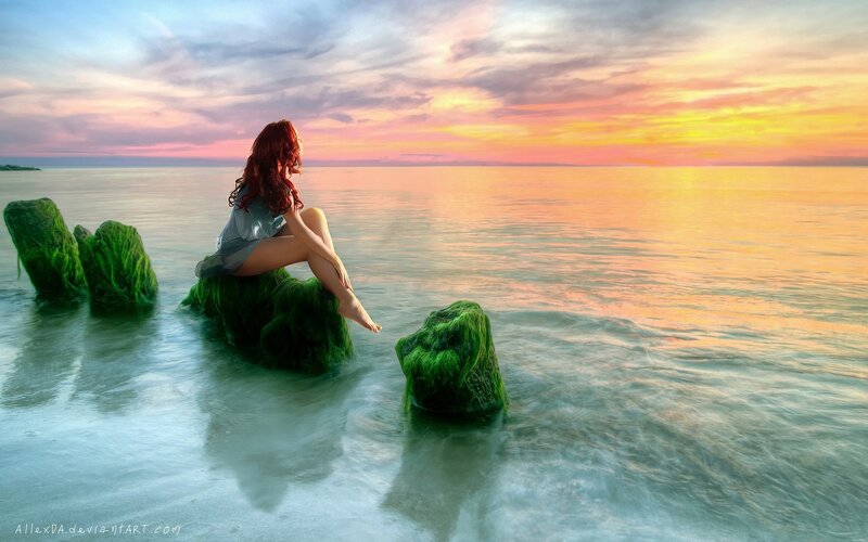 Woman on a rock at sunset