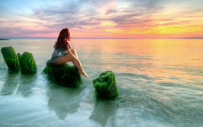 Woman on a rock at sunset