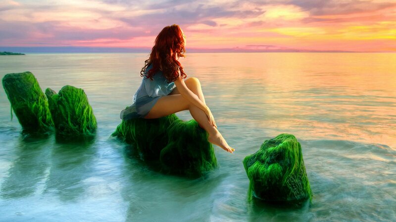 Woman on a rock at sunset