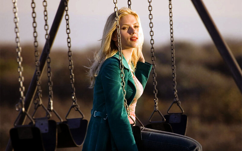 woman on a swing at sunset
