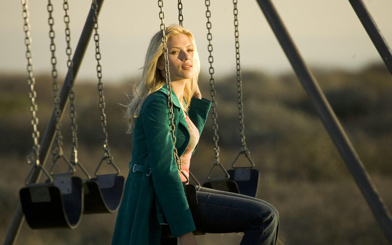 woman on a swing at sunset