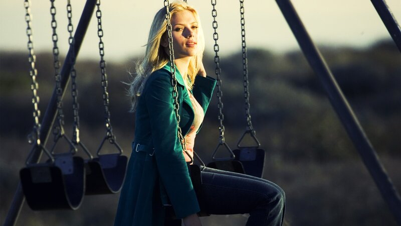 woman on a swing at sunset