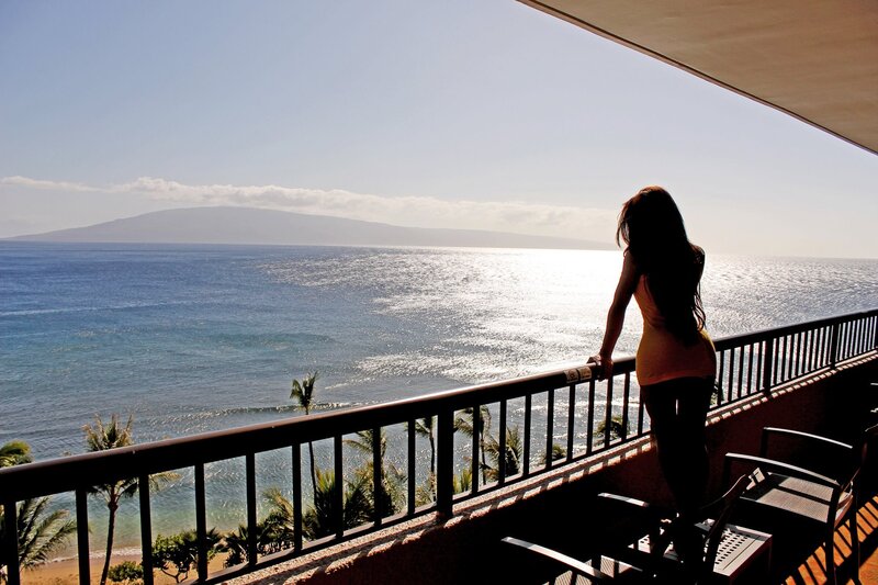 Woman on balcony overlooking ocean