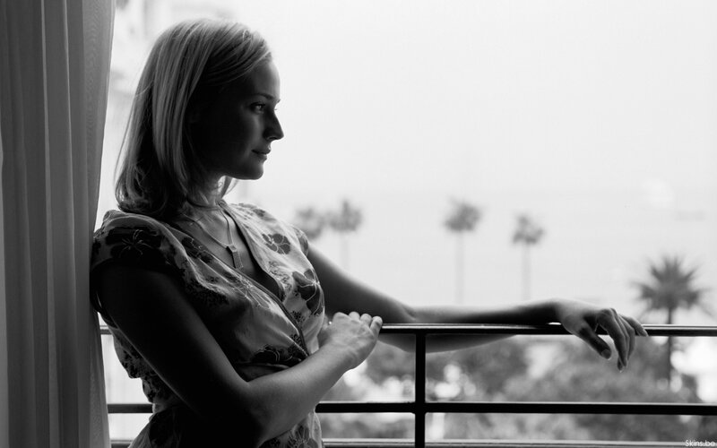 woman on balcony overlooking palm trees