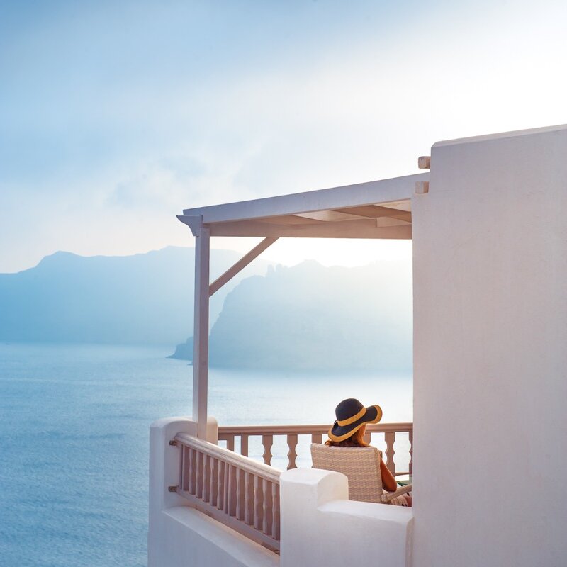 Woman on balcony overlooking sea