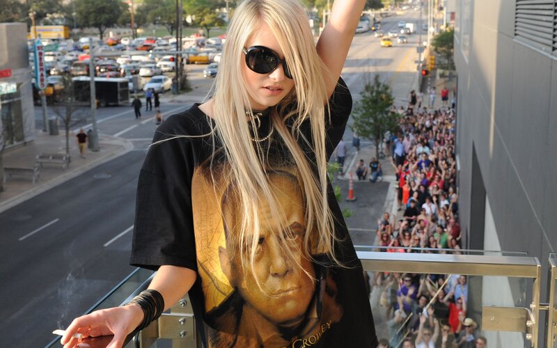Woman on balcony with crowd below