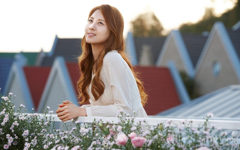woman on balcony with flowers