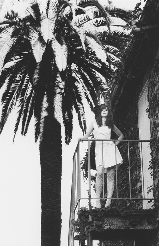 Woman on balcony with palm tree