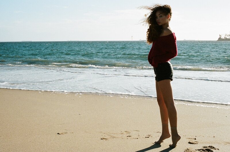 Woman on beach in red sweater