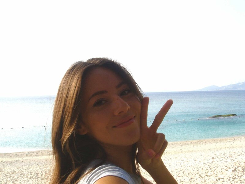 Woman on beach making peace sign