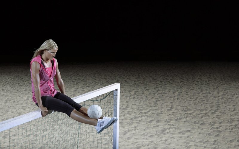 Woman on beach soccer goal