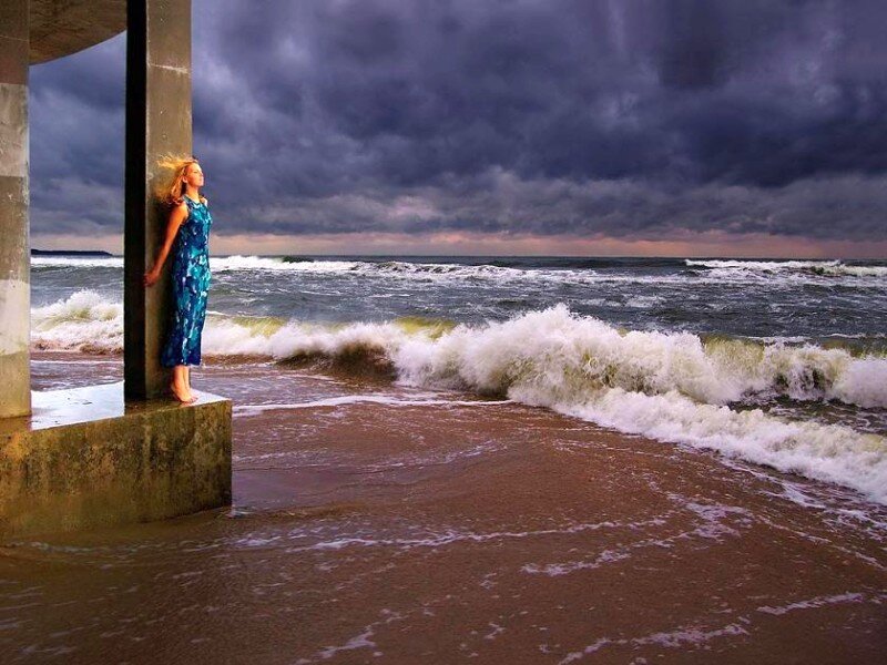 Woman on beach under stormy sky