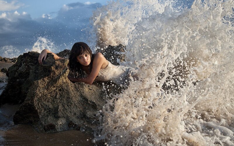 woman on beach with crashing wave