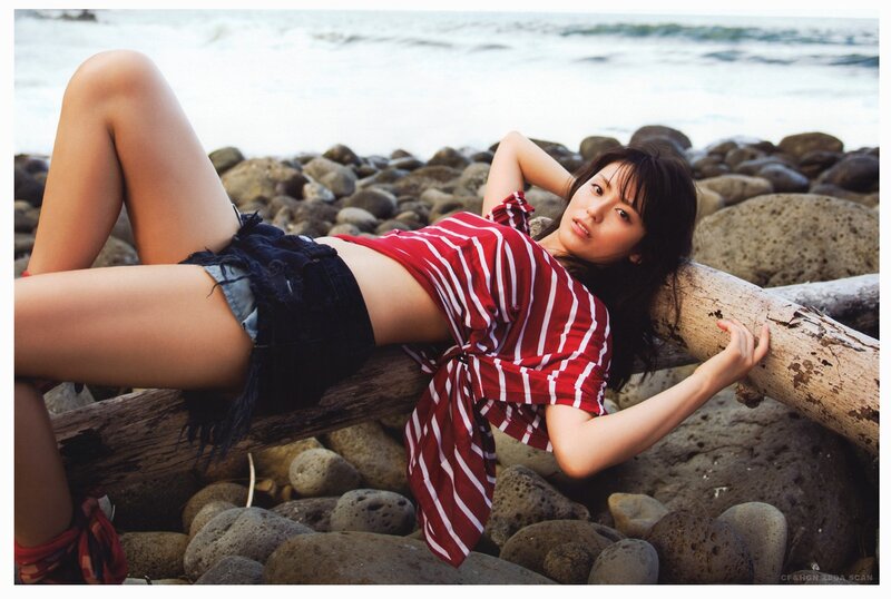 Woman on beach with driftwood