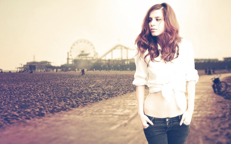 woman on beach with ferris wheel