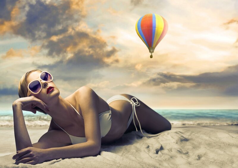 Woman on beach with hot air balloon
