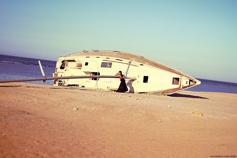 woman on beach with overturned boat