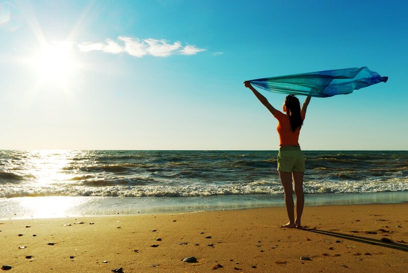 Woman on beach with scarf