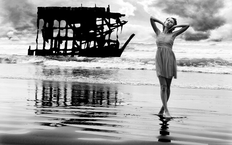woman on beach with shipwreck