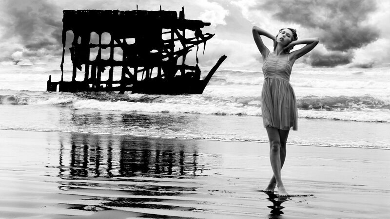 Woman on beach with shipwreck