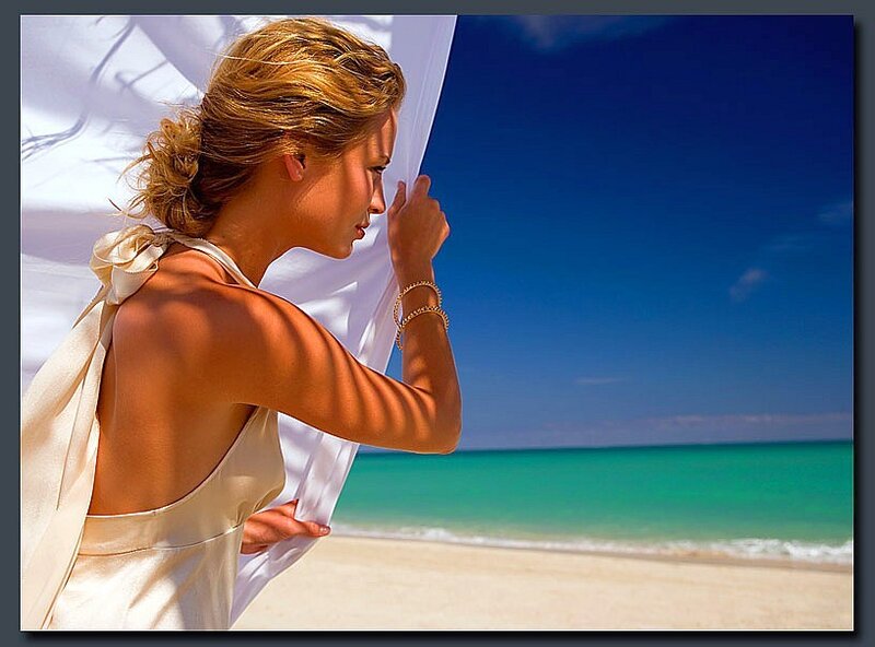 Woman on beach with white fabric